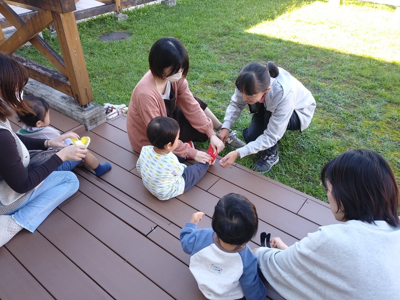 講師の成田が母親に、子どもの靴の正しい履き方を実演を交えて説明しています。