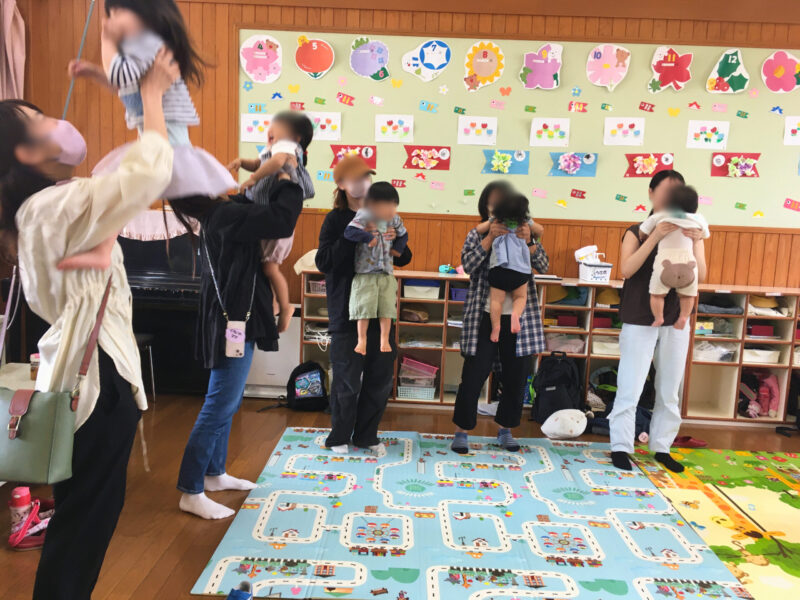 平和が丘幼稚園の子育て支援「すくすくクラブ」の講座風景。お母さんがわが子を「たかいたかい」して遊ぶ様子。(2025年5月21日)